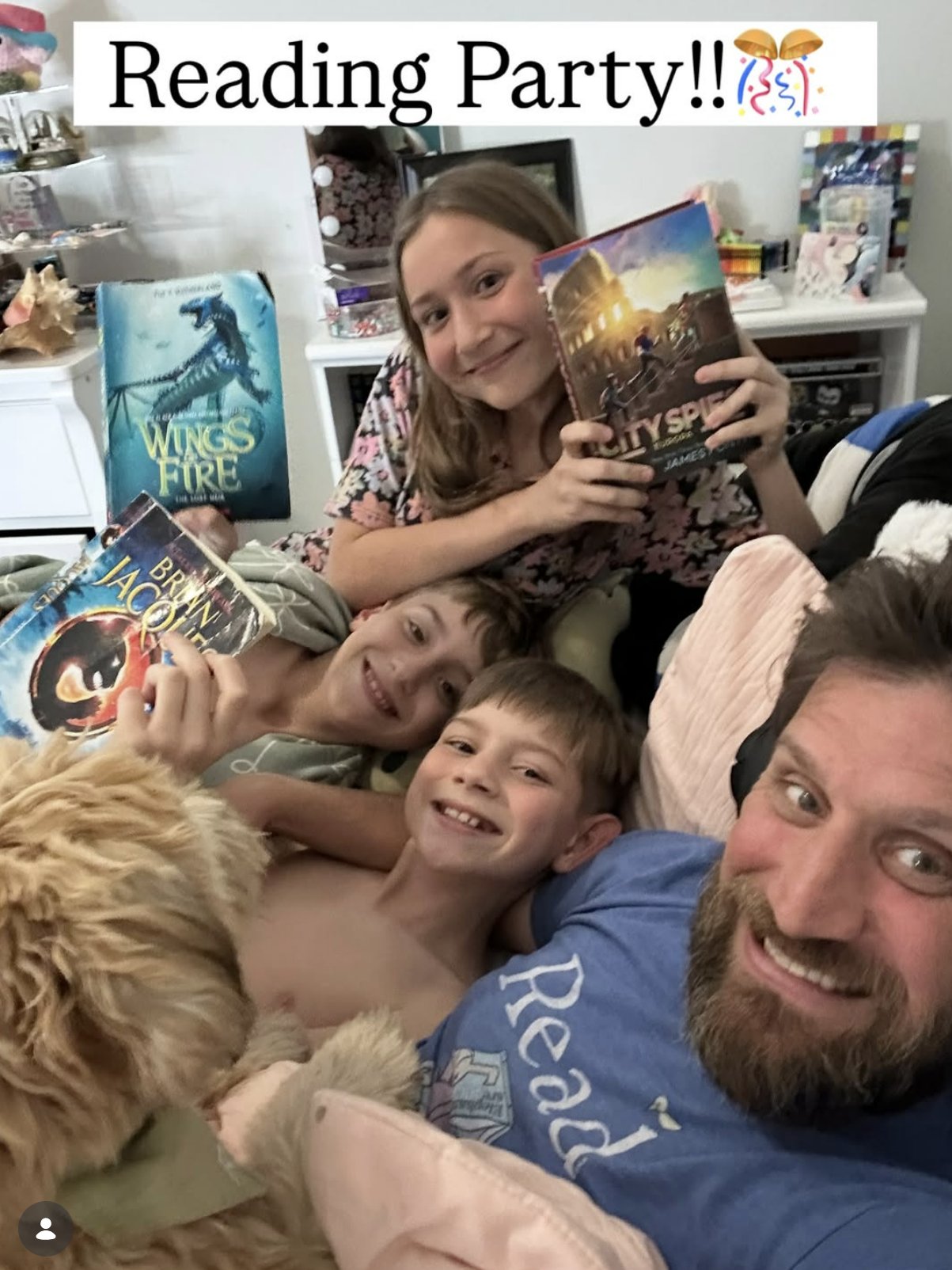 Rich and the three kids piled together with stacks of books